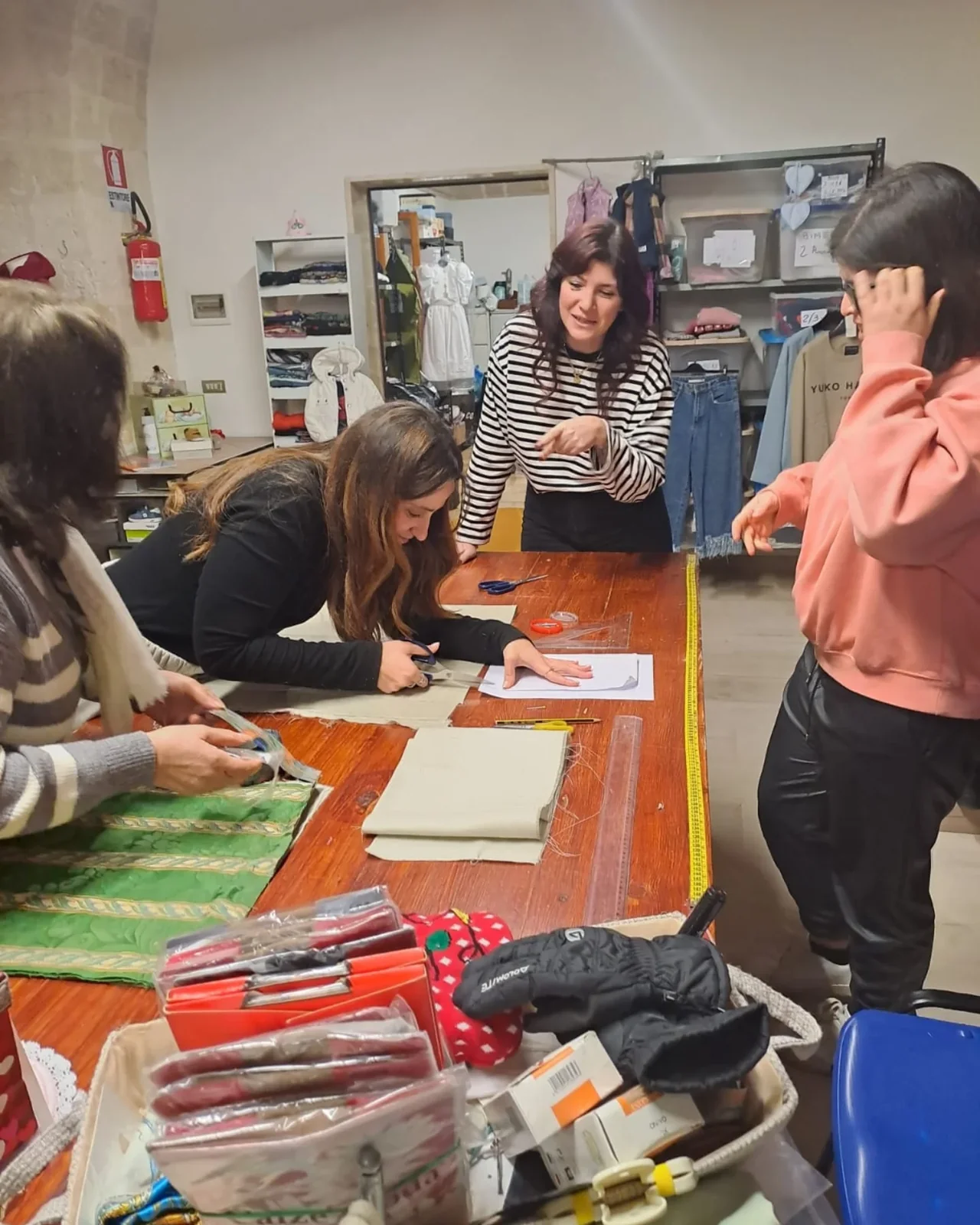 Confronto attorno al tavolo di lavoro della Sartoria Sociale Caritas.