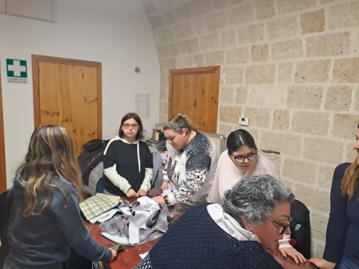 Partecipanti riuniti attorno al tavolo della Sartoria Sociale.
