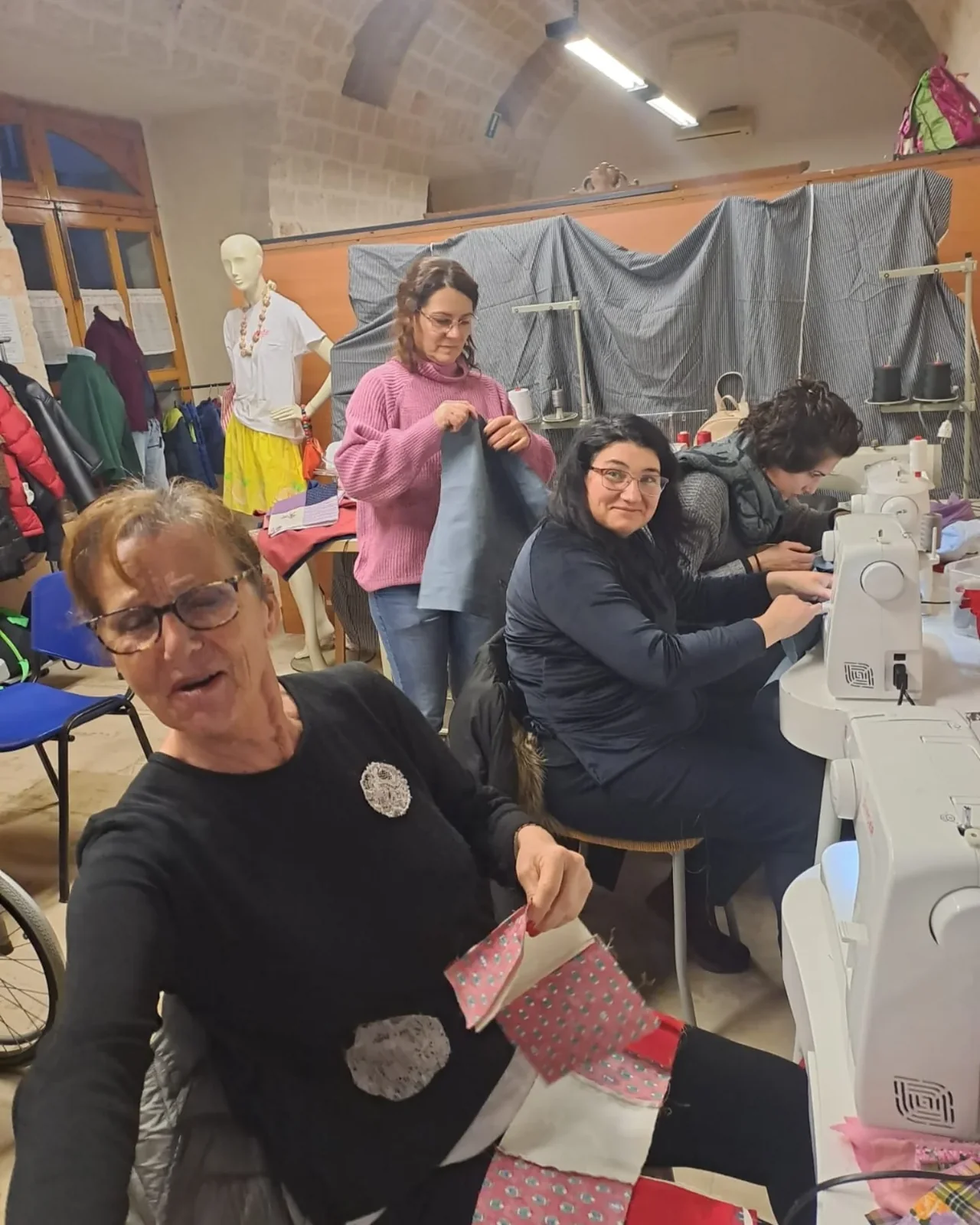 Partecipanti insieme nell’area delle macchine da cucire.